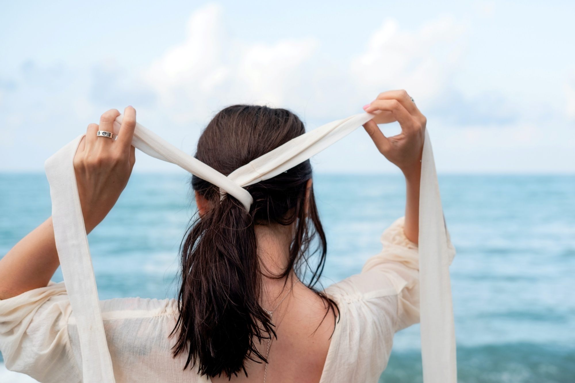 Woman putting a ribbon hair tie on her hair