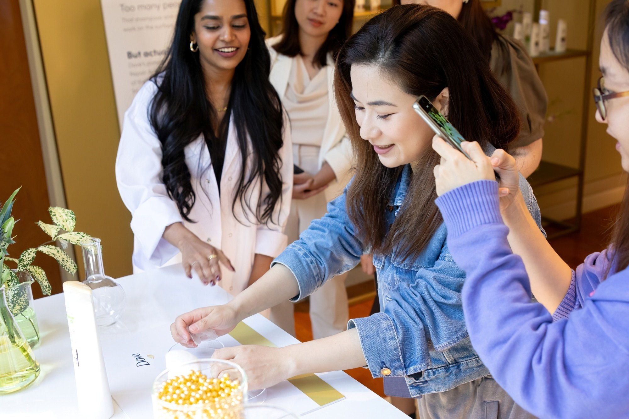 Asian experts and guests testing hair care products at an event
