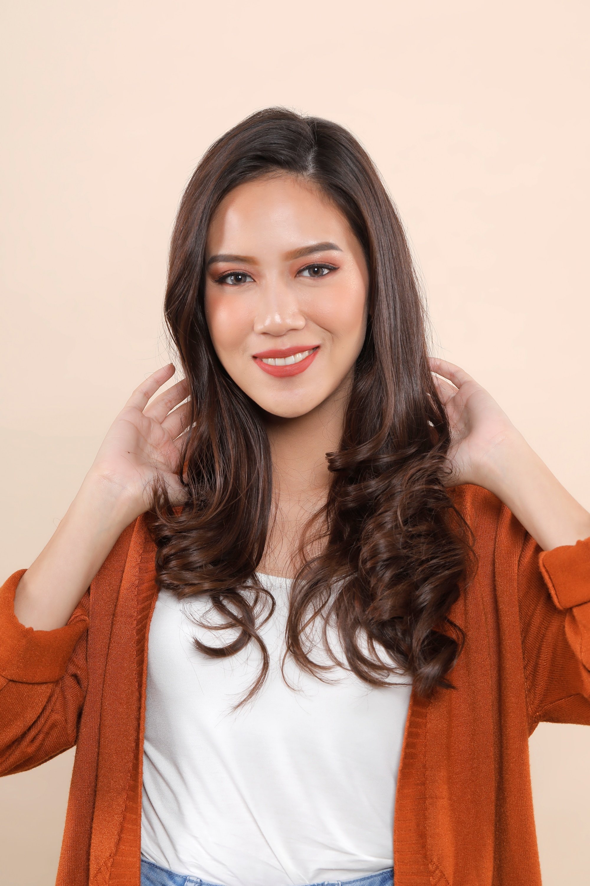 Asian woman touching her long wavy hair
