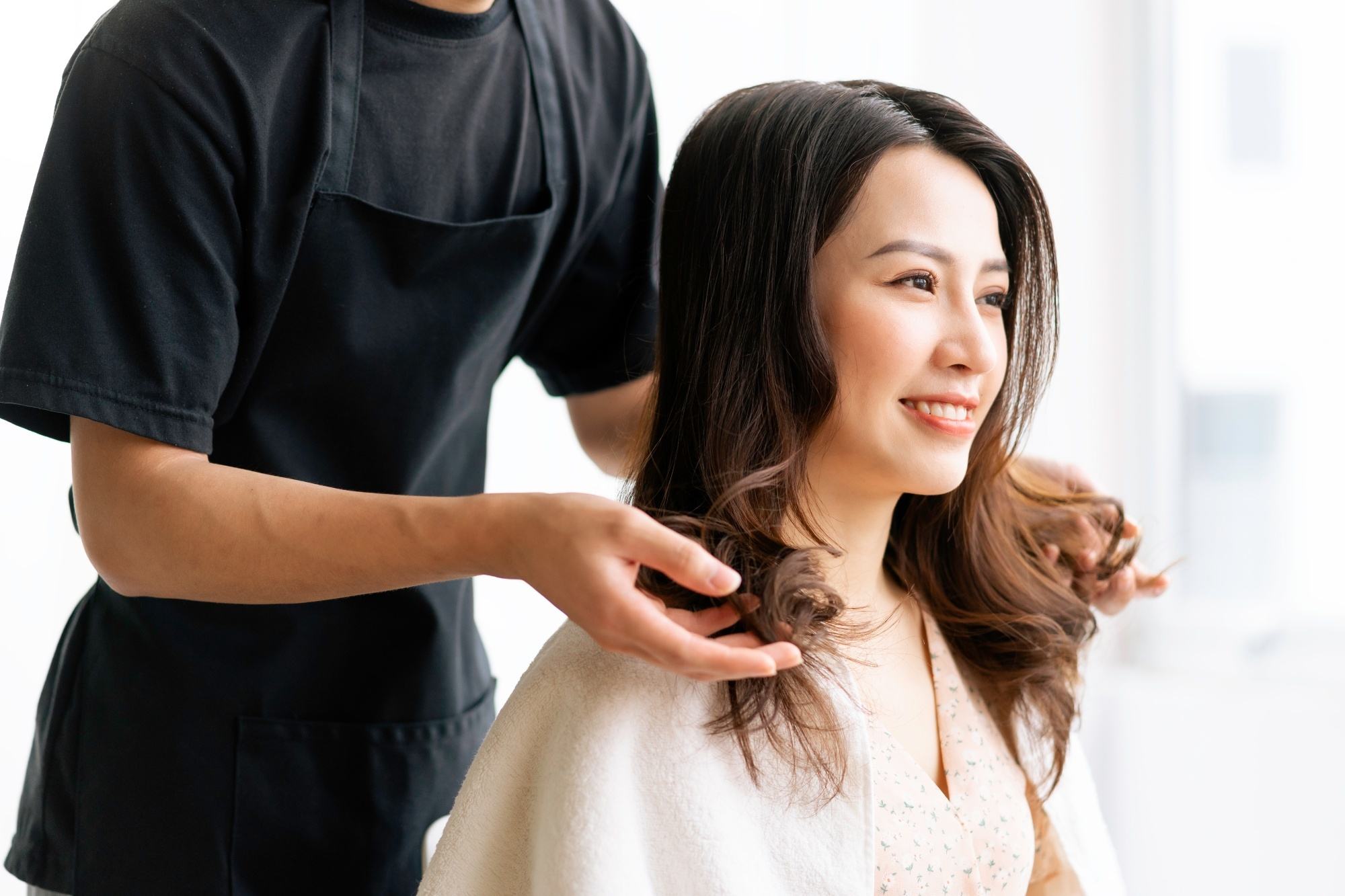 Asian woman at the salon looking at the result of the salon treatment