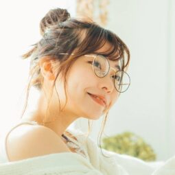 Asian woman with a messy bun hairstyle wearing eyeglasses.