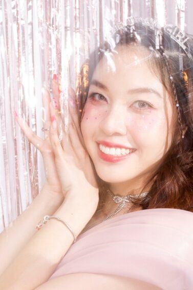 Asian woman posing with tinsels near her hair