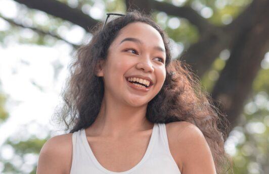 Filipino woman with long curly hair smiling.