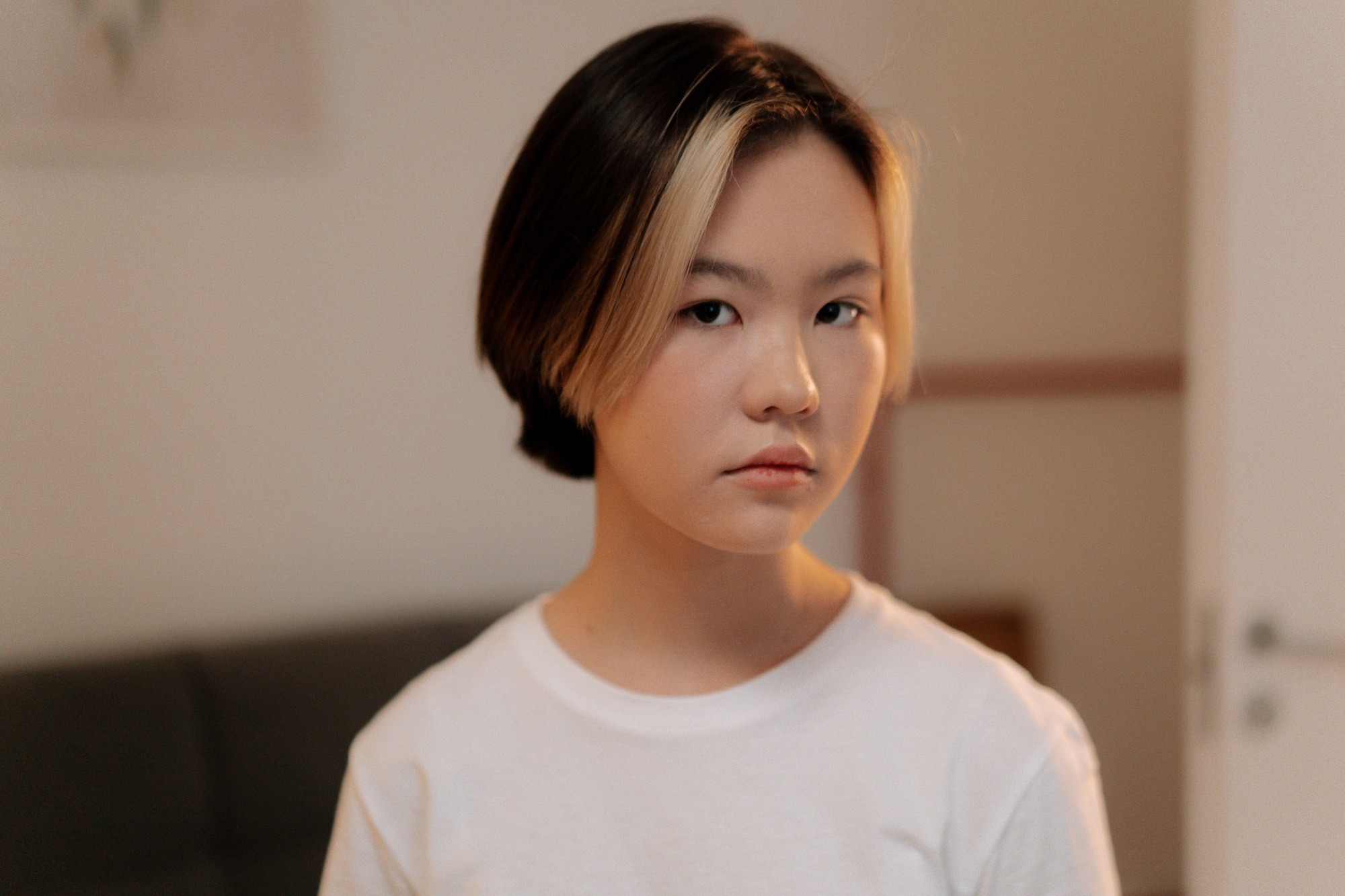 Asian woman with short hair and blonde face-framing highlights