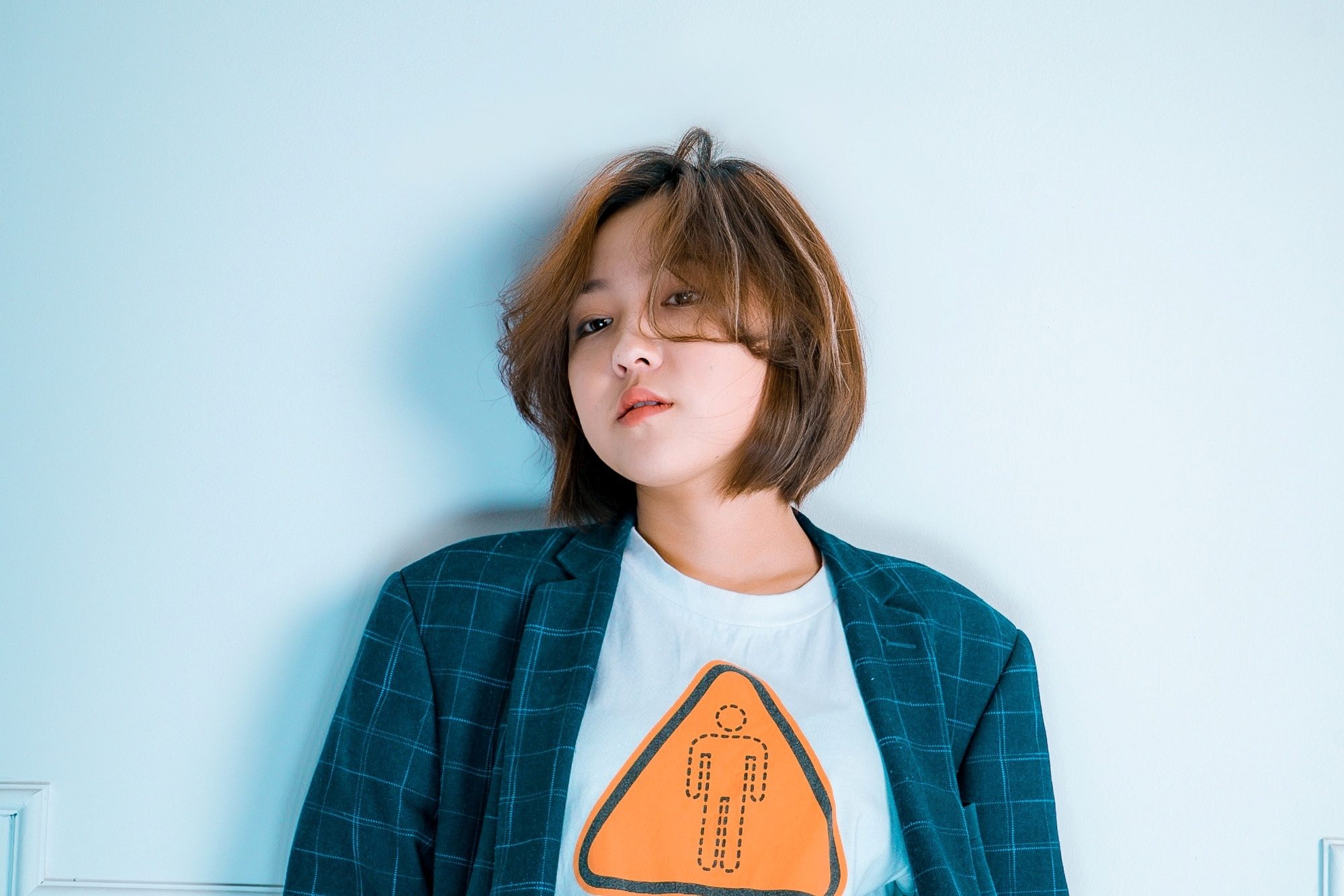 Asian woman with short brown hair wearing a blue jacket.