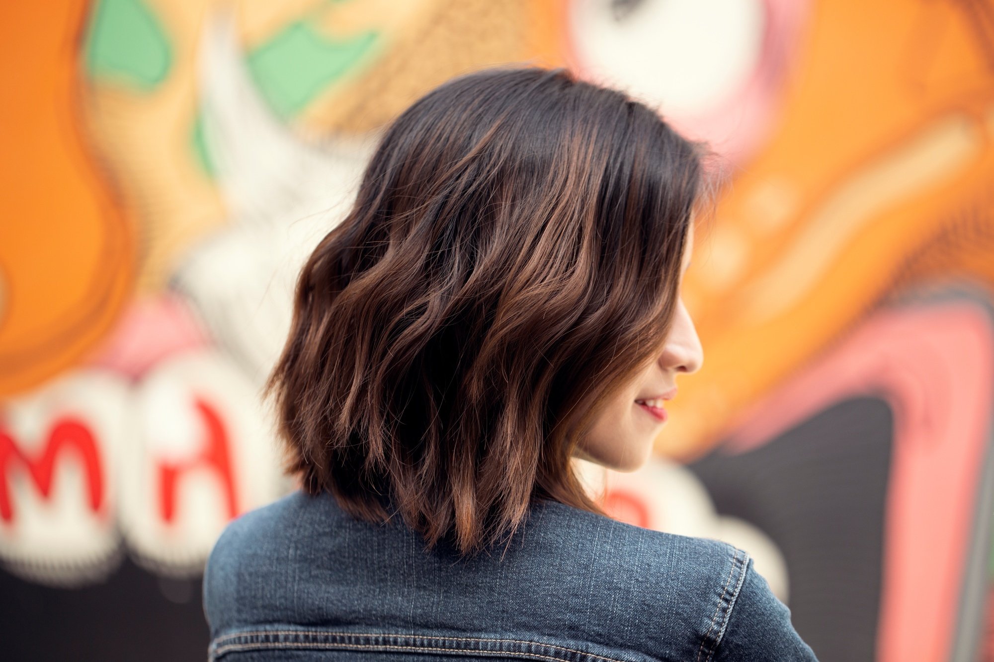 Side view of an Asian woman's short hair with caramel highlights.