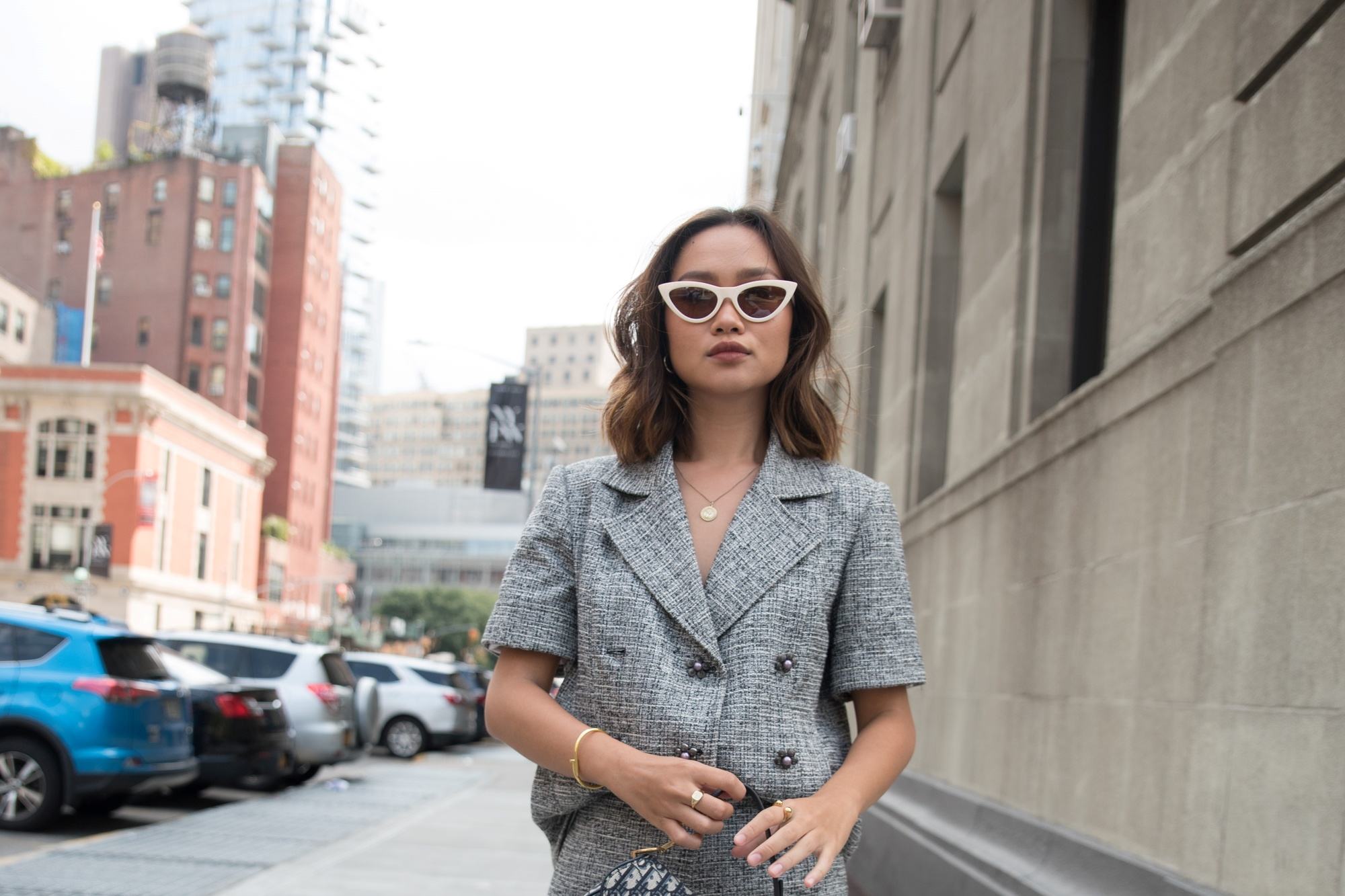 Asian woman with a tousled long bob wearing a gray business attire.