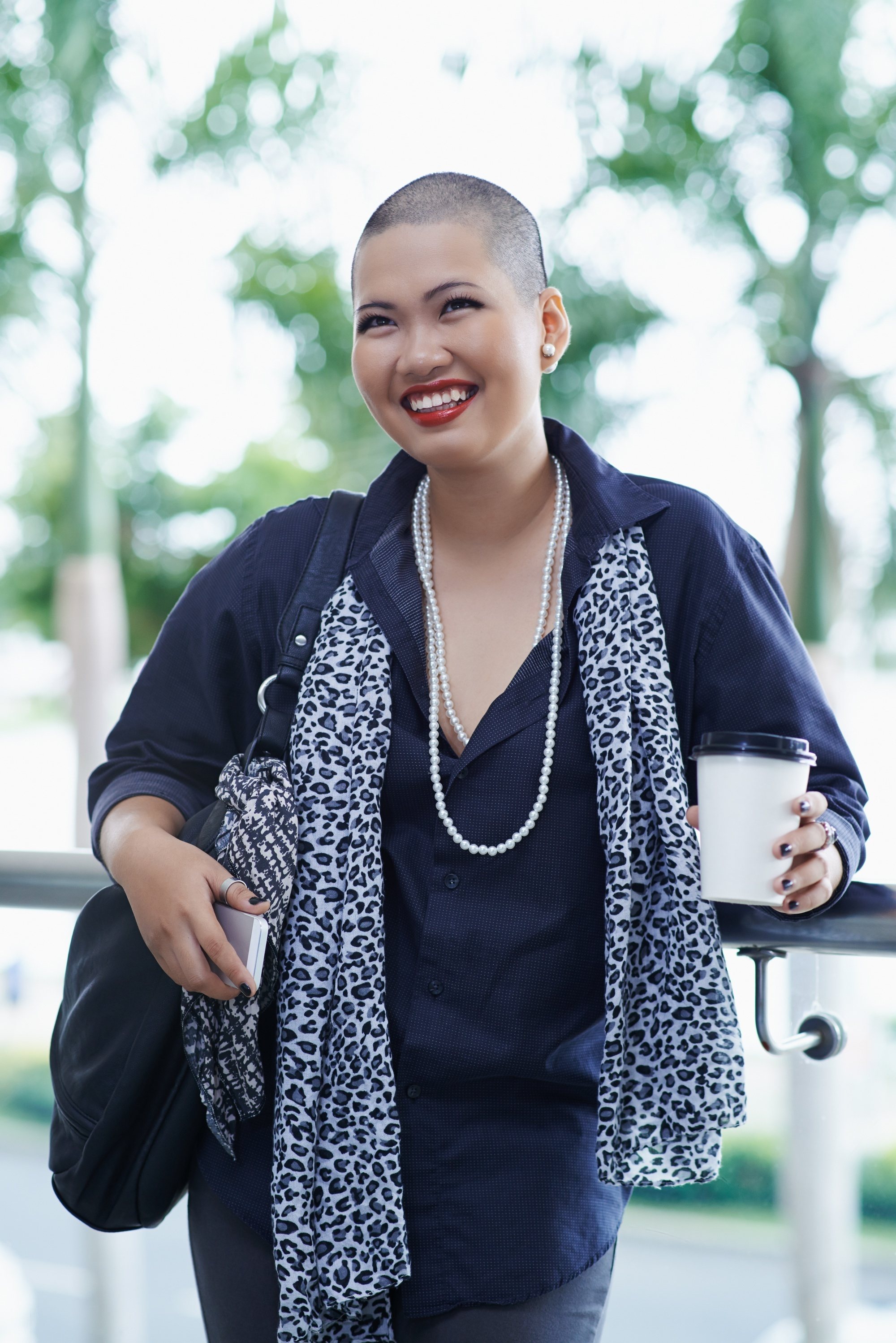 Asian woman with a buzz cut smiling.