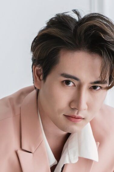 Asian man with brown hair highlights for men wearing a pink suit.