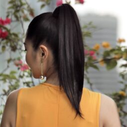 Back of an Asian woman with V-cut hair in a high ponytail.